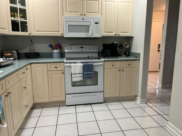 a kitchen with white cabinets a sink dishwasher and a stove with wooden floor