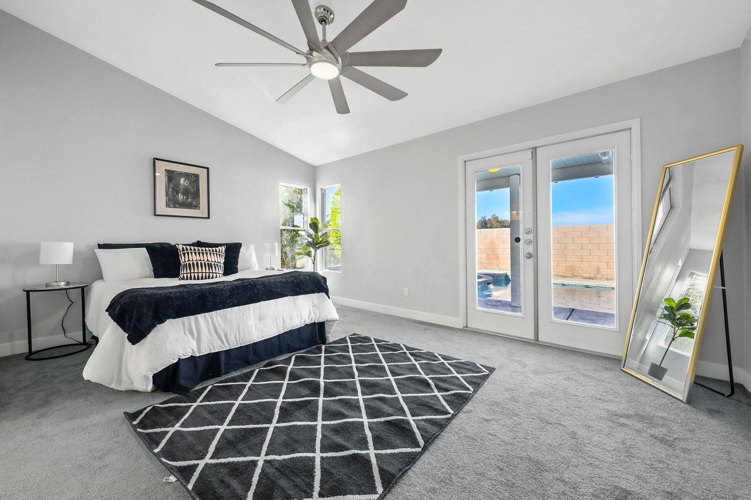 Undisclosed Address Palm Desert, CA 92211 - Photo 20 of 31 a bedroom with a large bed and a chandelier fan