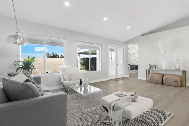 a view of a big room with windows and ceiling fan