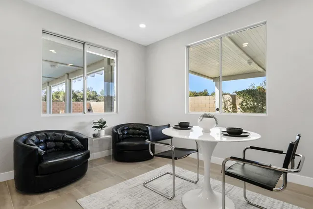 a bedroom with a large bed and a chandelier fan