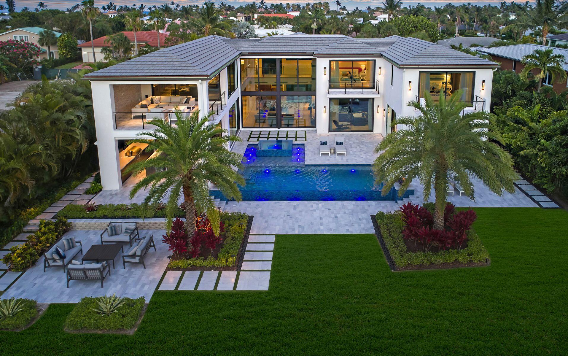102 Lighthouse Drive Jupiter Inlet Colony, FL 33469 - Photo 2 of 18 a front view of a house with a garden