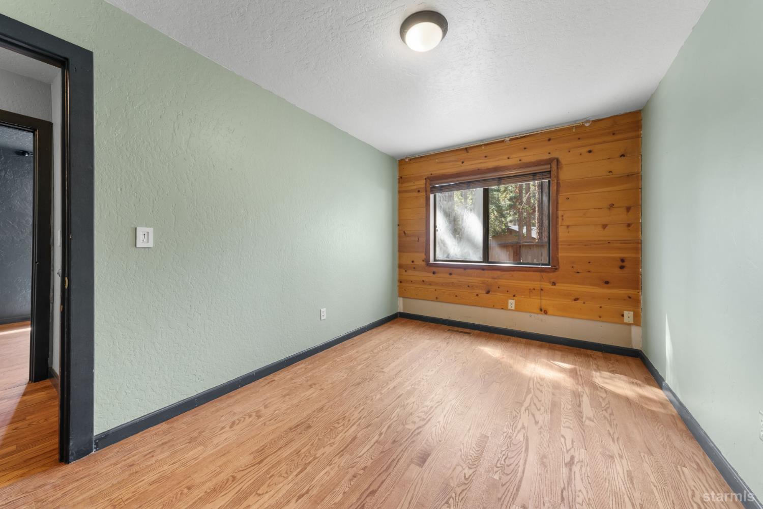 712 Seneca Drive South Lake Tahoe, CA 96150 - Photo 13 of 28 an empty room with wooden floor and windows