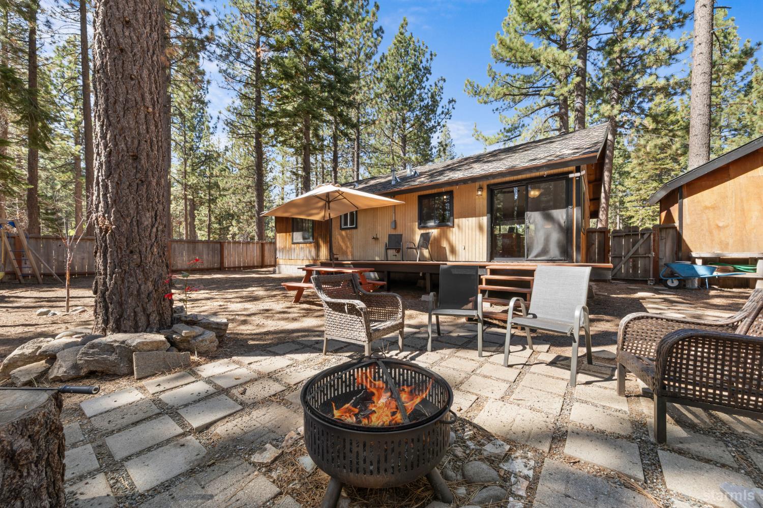 712 Seneca Drive South Lake Tahoe, CA 96150 - Photo 16 of 28 a view of a patio with table and chairs potted plants and a large tree