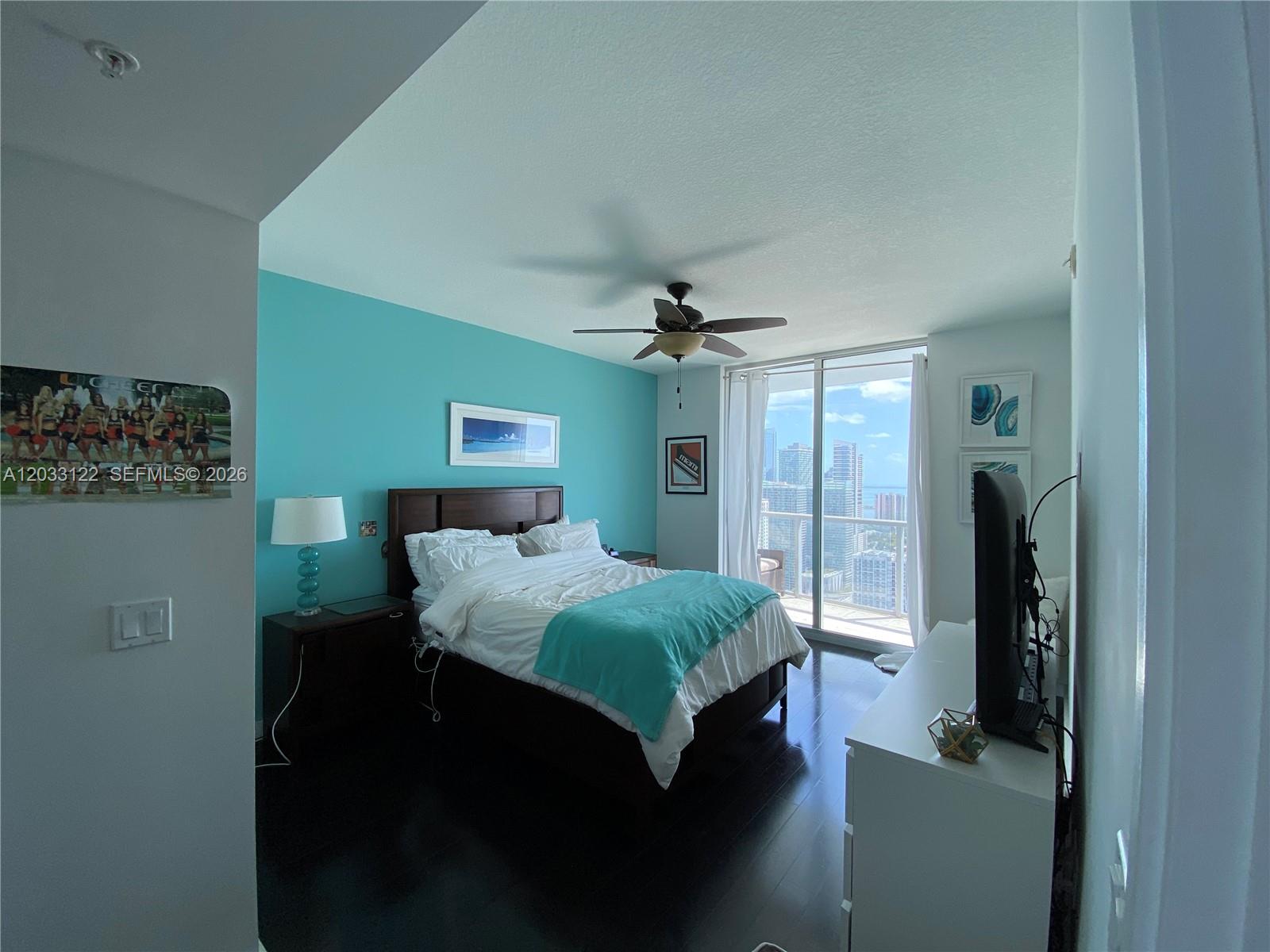 185 Southwest 7th Street, Unit 4206 Miami, FL 33130 - Photo 15 of 26 a bedroom with a bed and a chandelier