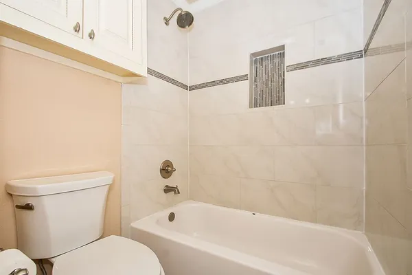 a bathroom with a granite countertop toilet sink and mirror