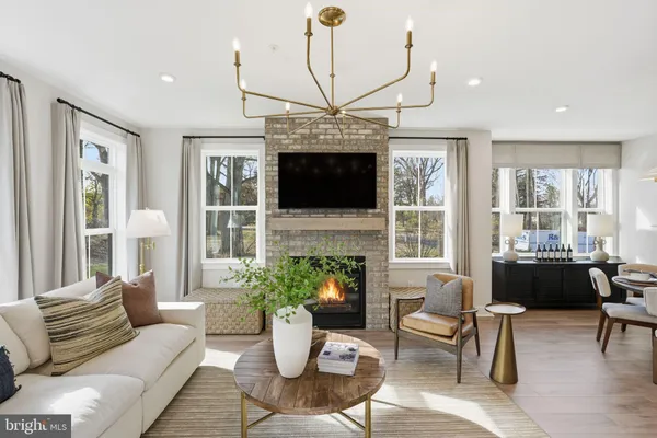 a living room with furniture a fireplace and a chandelier