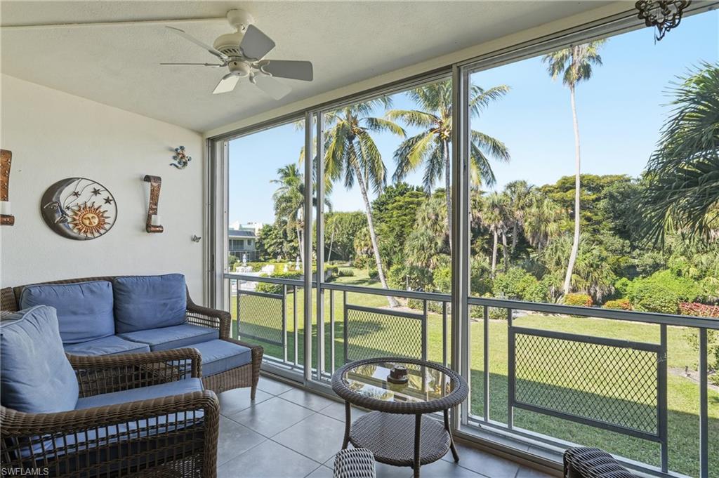 Sunroom / solarium with tile patterned flooring and view of wooded area