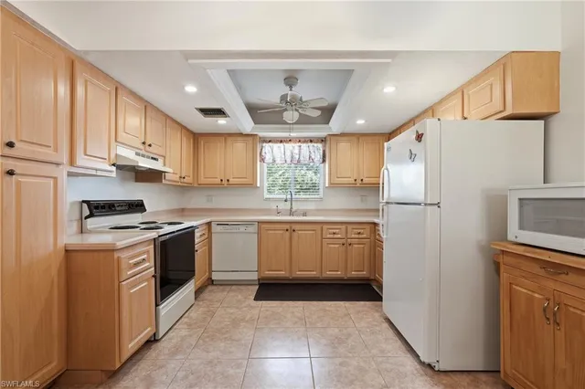 a kitchen with a refrigerator sink and cabinets