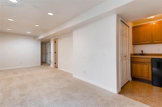 9231 Ballybunion Road Peyton, CO 80831 - Photo 19 of 26 Basement family room with wet bar to the right.