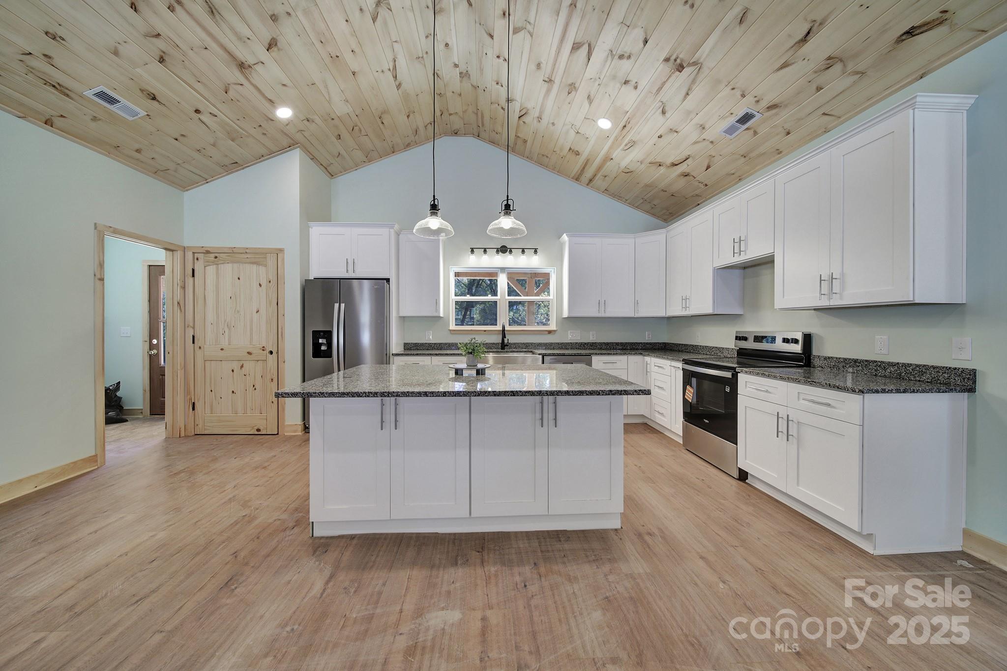 230 East Doc Garris Road Lancaster, SC 29720 - Photo 13 of 31 a kitchen with granite countertop a stove cabinets and wooden floor