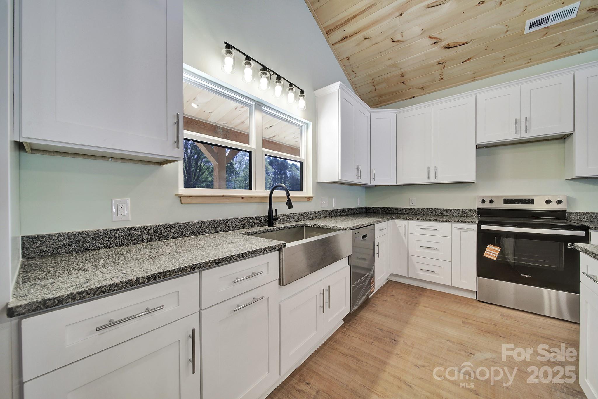 230 East Doc Garris Road Lancaster, SC 29720 - Photo 16 of 31 a kitchen with granite countertop white cabinets and white appliances