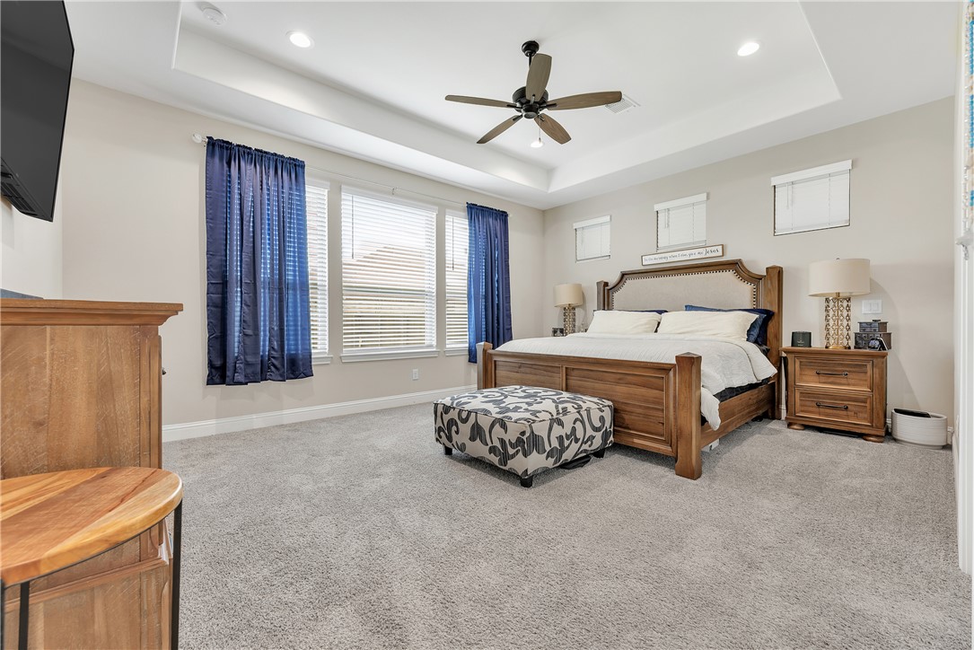 4355 Fox River Lane Bryan, TX 77802 - Photo 13 of 36 a spacious bedroom with a bed a couch and a ceiling fan