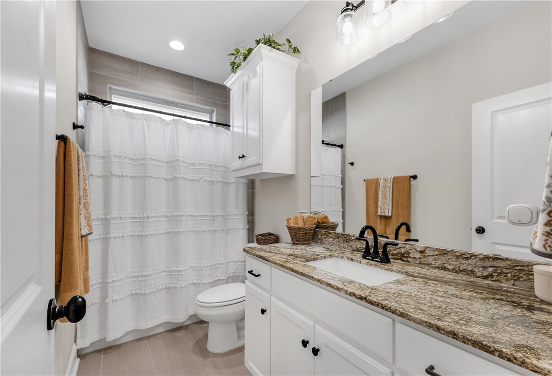 4355 Fox River Lane Bryan, TX 77802 - Photo 18 of 36 a bathroom with a granite countertop sink toilet and shower