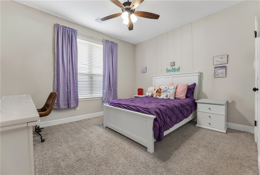 4355 Fox River Lane Bryan, TX 77802 - Photo 19 of 36 a spacious bedroom with a bed and a chandelier