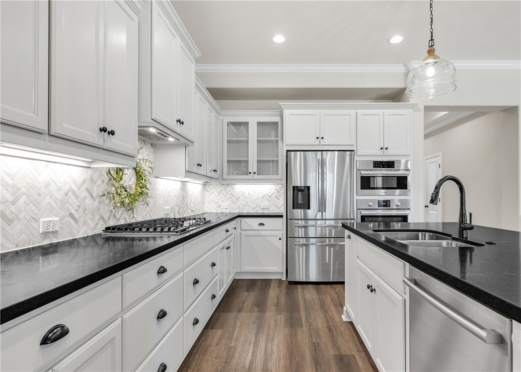 4355 Fox River Lane Bryan, TX 77802 - Photo 6 of 36 a kitchen with stainless steel appliances granite countertop a sink dishwasher a refrigerator and white cabinets with wooden floor