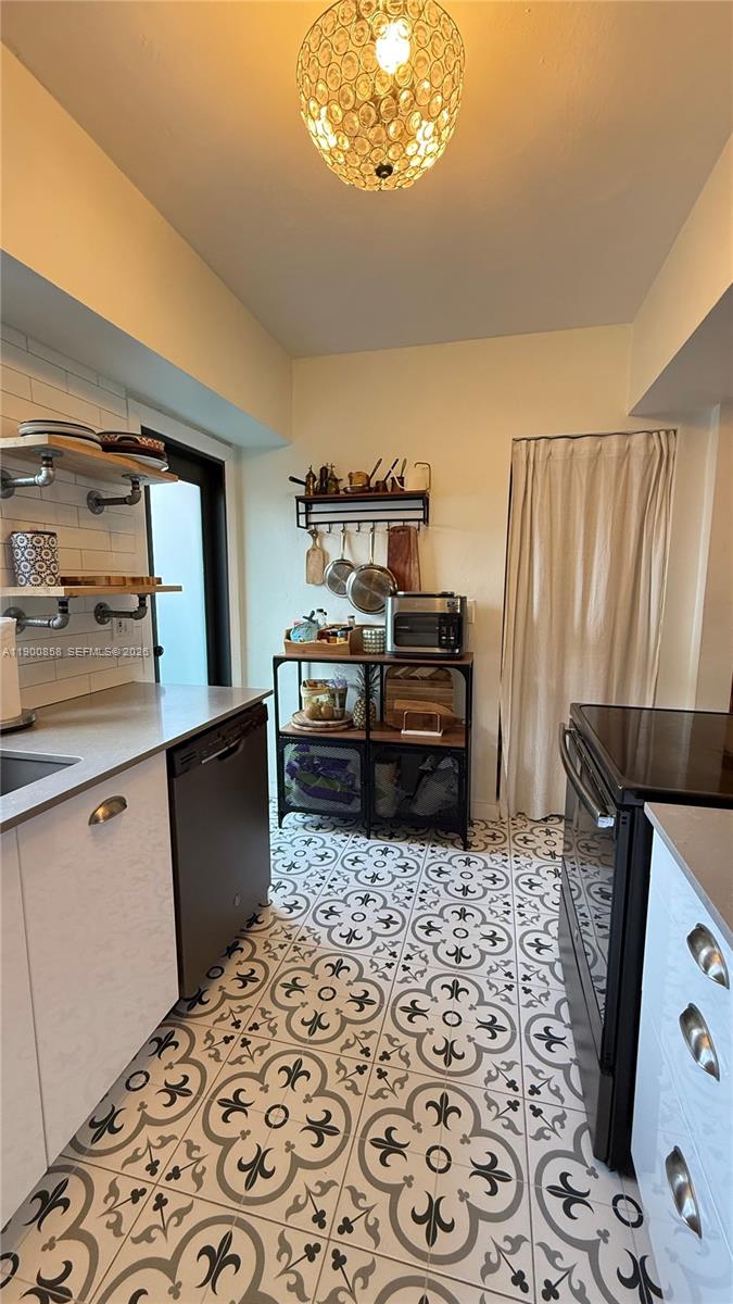 2 Northeast 44th Street Miami, FL 33137 - Photo 12 of 25 a kitchen with stainless steel appliances a sink a stove a refrigerator and cabinets