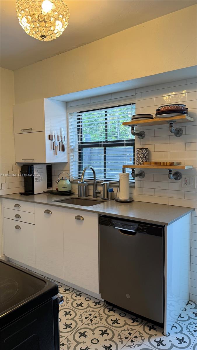 2 Northeast 44th Street Miami, FL 33137 - Photo 9 of 25 a kitchen with stainless steel appliances granite countertop a sink stove and window