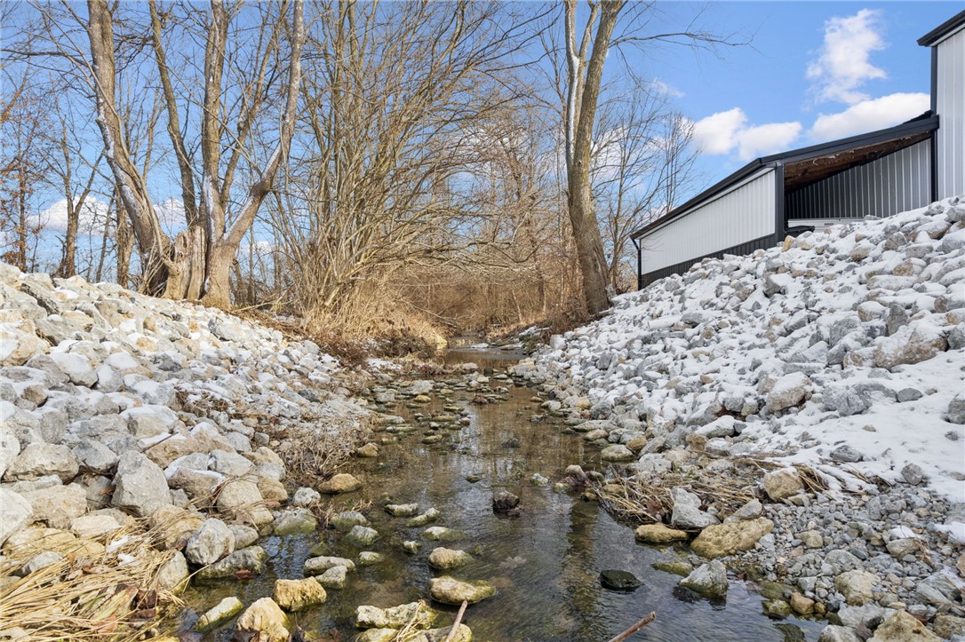 1602 Westboro Road Blanchester, OH 45107 - Photo 37 of 81 A tranquil creek winds through a landscape, with a modern structure nestled beside it.