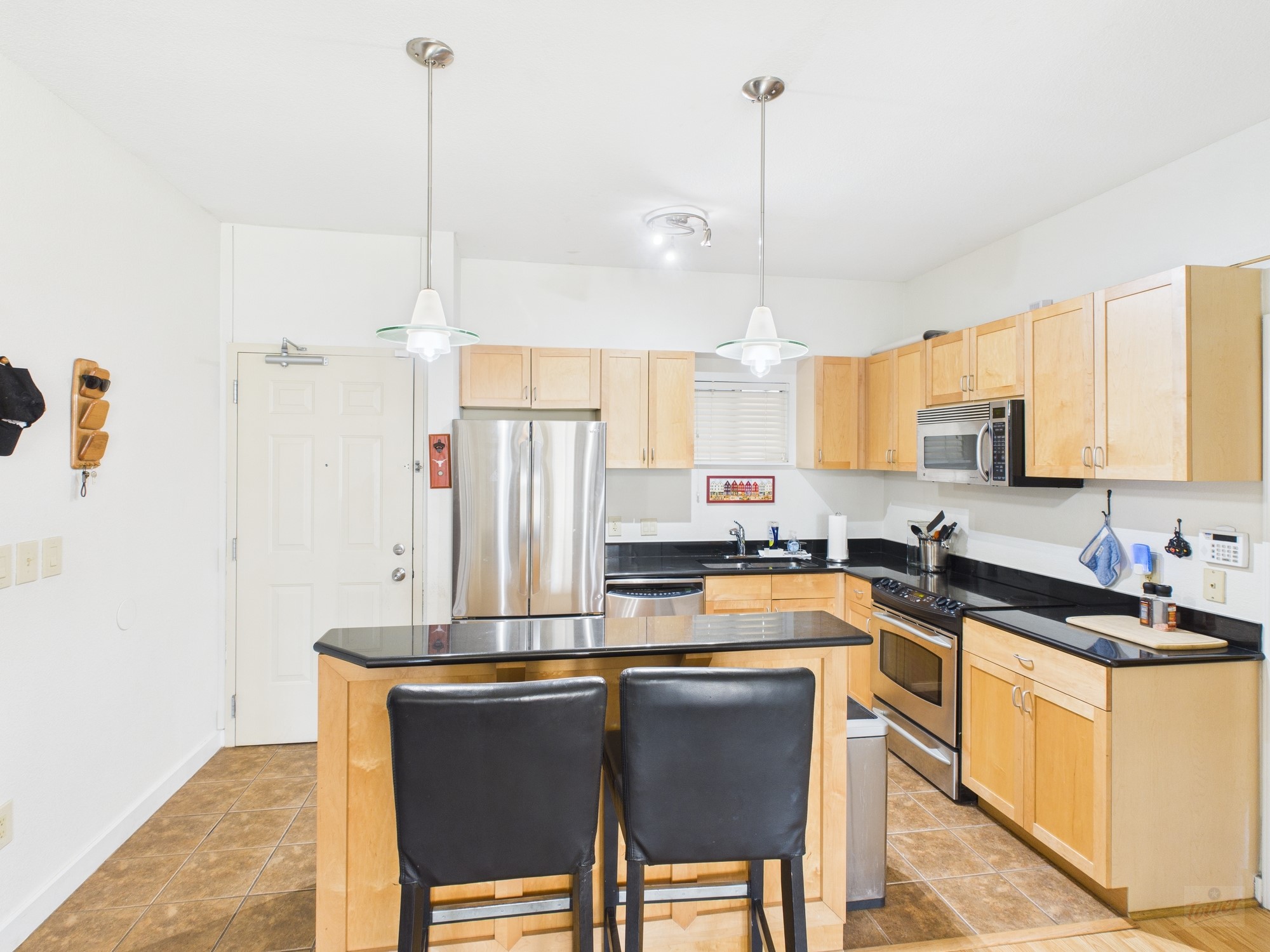711 West 26th Street, Unit 606 Austin, TX 78705 - Photo 3 of 11 a kitchen with stainless steel appliances granite countertop a sink a stove a refrigerator a center island and a window