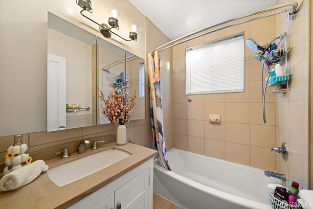 a bathroom with a tub sink and mirror