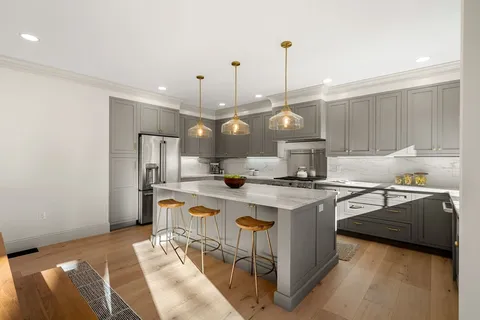a kitchen with stainless steel appliances granite countertop a sink a stove and a refrigerator