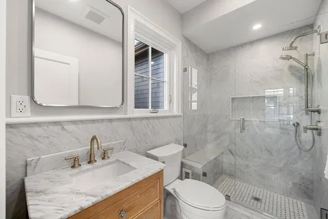 a bathroom with a granite countertop sink toilet and shower