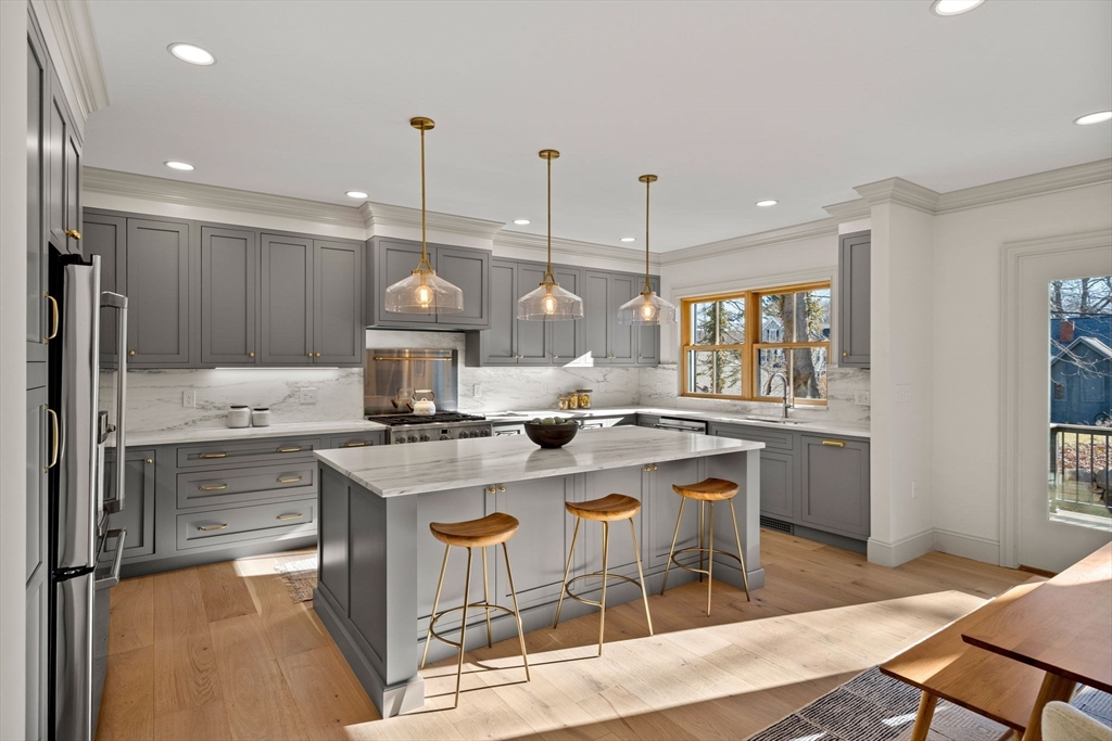 7 Flatley Avenue Manchester, MA 01944 - Photo 10 of 42 a kitchen with a stove a refrigerator and a dining table with wooden floor