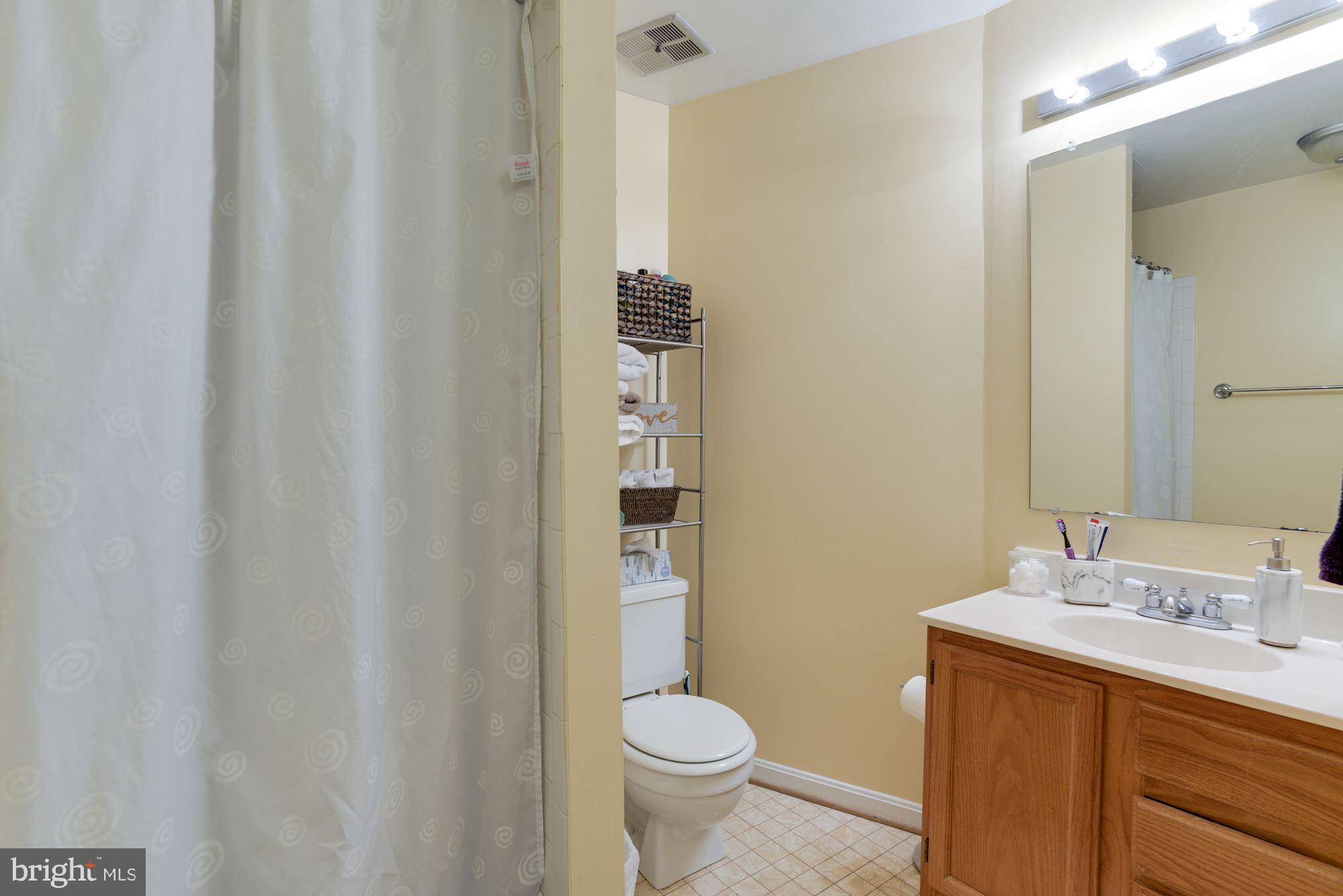 1704 Quietree Drive Reston, VA 20194 - Photo 23 of 23 a bathroom with a granite countertop sink toilet and a mirror