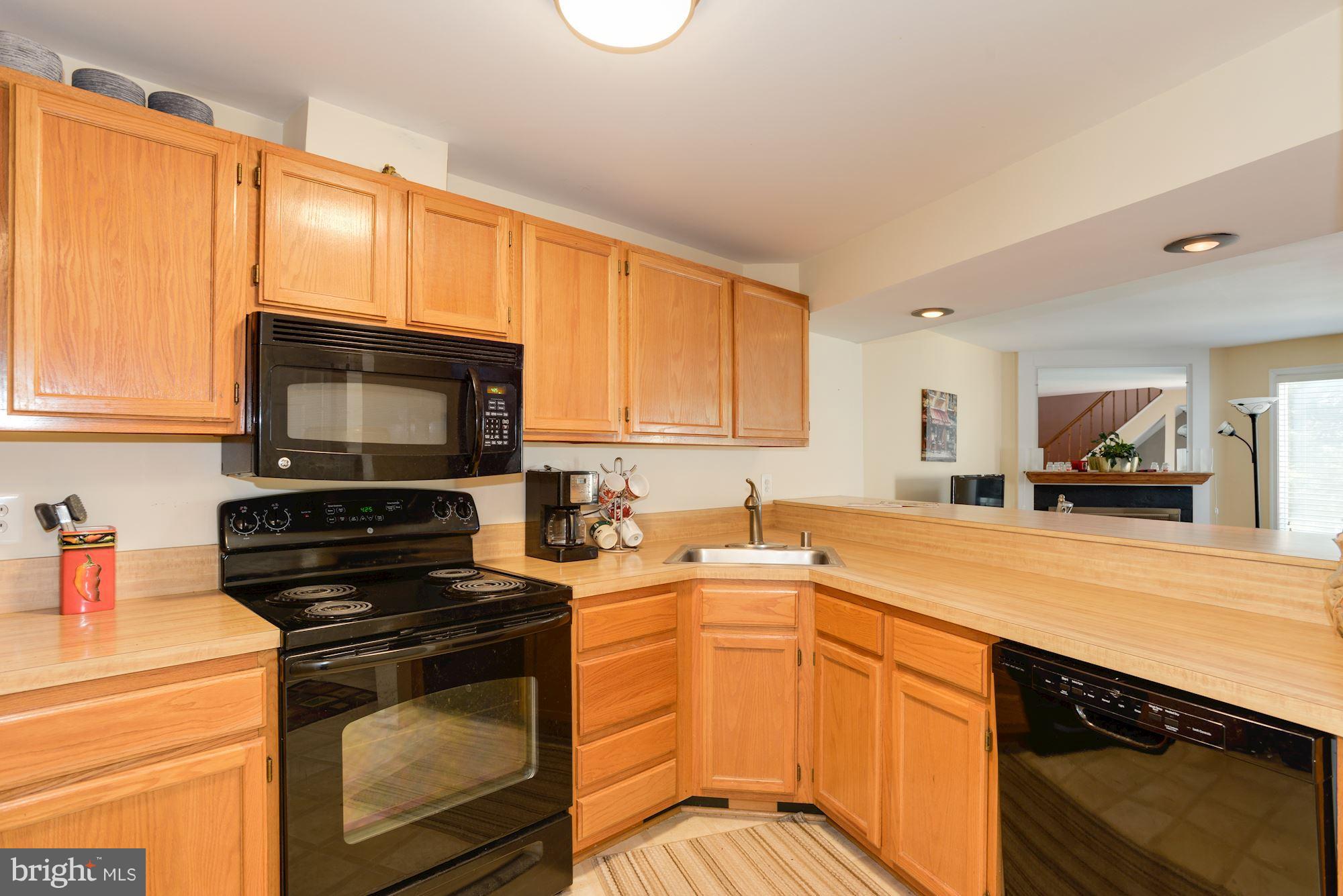 1704 Quietree Drive Reston, VA 20194 - Photo 4 of 23 a kitchen with stainless steel appliances a stove sink microwave and cabinets