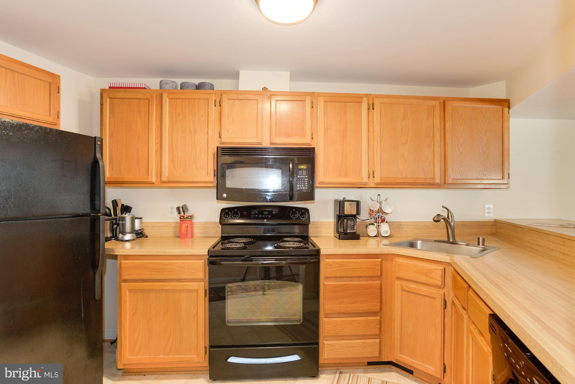 1704 Quietree Drive Reston, VA 20194 - Photo 6 of 23 a kitchen with stainless steel appliances a refrigerator stove and sink