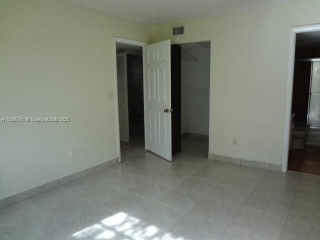 18216 Mediterranean Boulevard, Unit 119 Hialeah, FL 33015 - Photo 15 of 42 an empty room with closet and a flat screen tv
