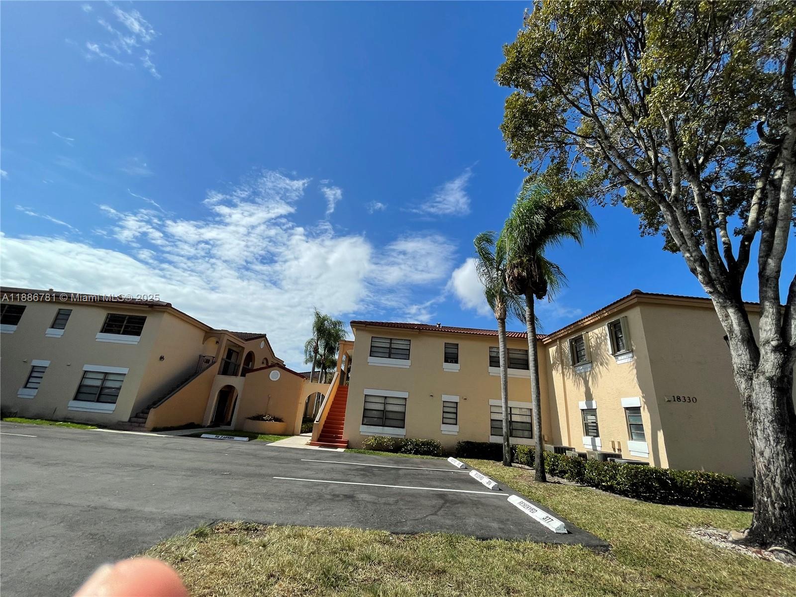 18216 Mediterranean Boulevard, Unit 119 Hialeah, FL 33015 - Photo 23 of 42 a front view of a house with a yard