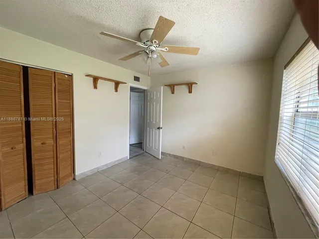 an empty room with closet and windows