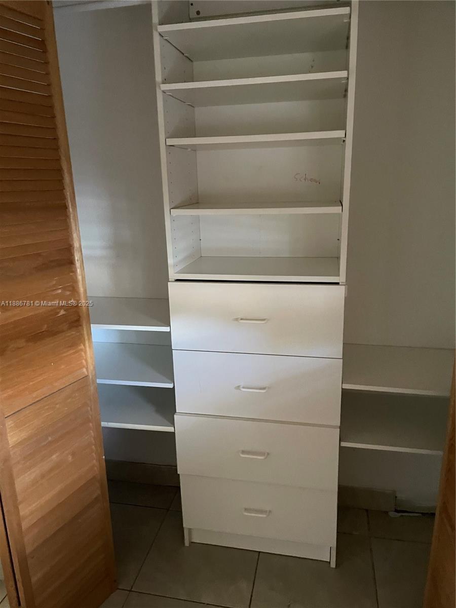 18216 Mediterranean Boulevard, Unit 119 Hialeah, FL 33015 - Photo 30 of 42 a view of walk in closet with empty racks