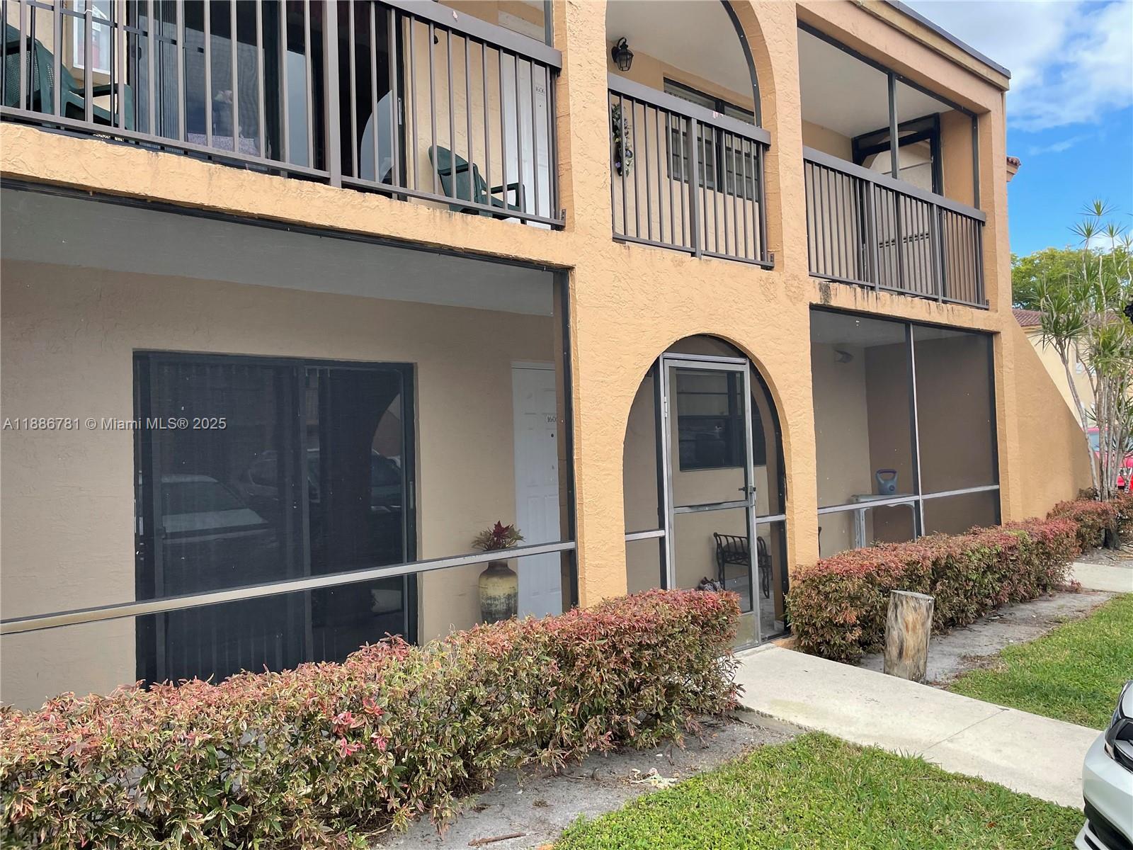 18216 Mediterranean Boulevard, Unit 119 Hialeah, FL 33015 - Photo 32 of 42 a front view of a house with a garden