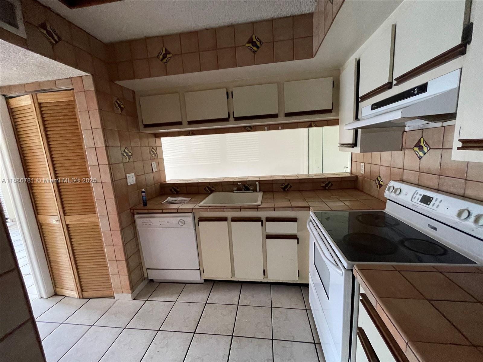 18216 Mediterranean Boulevard, Unit 119 Hialeah, FL 33015 - Photo 37 of 42 a kitchen with a stove and a sink