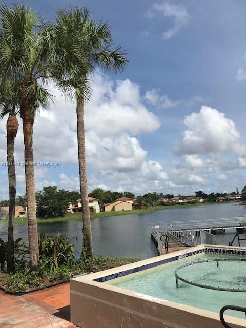 18216 Mediterranean Boulevard, Unit 119 Hialeah, FL 33015 - Photo 8 of 42 a view of a lake with houses in the background