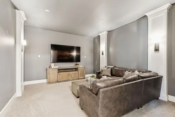 a living room with furniture white walls and kitchen view