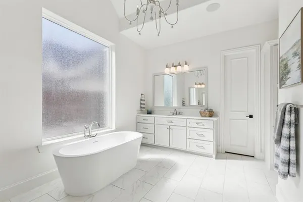 a spacious bathroom with a double vanity sink a mirror and a bathtub