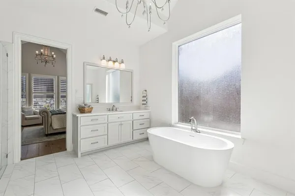 a spacious bathroom with a bathtub sink and mirror