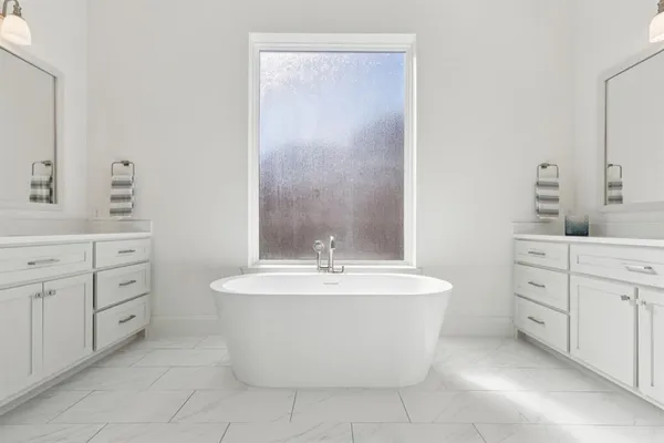 a spacious bathroom with a double vanity sink mirror and shower