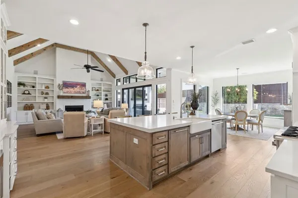 a large kitchen with lots of counter space a sink appliances and a dining table