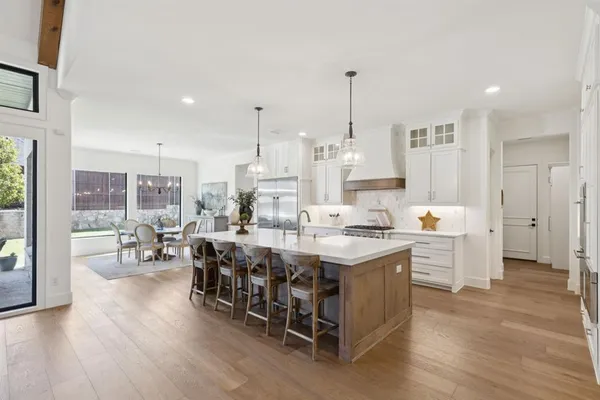 a kitchen with stainless steel appliances granite countertop a kitchen island hardwood floor and a sink