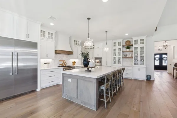 a kitchen with stainless steel appliances a sink a stove top oven a counter space and cabinets