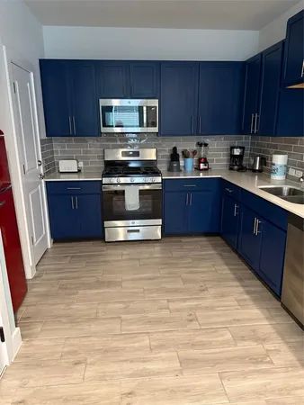 a kitchen with stainless steel appliances granite countertop a stove refrigerator a sink and dishwasher with wooden cabinets