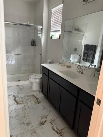 a bathroom with a sink toilet a mirror and shower