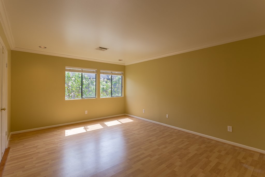 2349 Albans Road, Unit 2 Houston, TX 77005 - Photo 16 of 25 Experience the serenity of this primary bedroom, featuring abundant natural light, warm hues, and sleek engineered wood floors, perfect for your personal retreat.