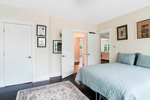 a bedroom with a large bed and a wooden floor