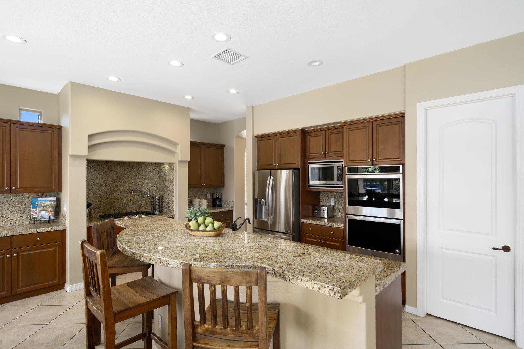 48640 Cascade Street Indio, CA 92201 - Photo 29 of 49 a kitchen with stainless steel appliances granite countertop a kitchen island a stove a dining table and chairs