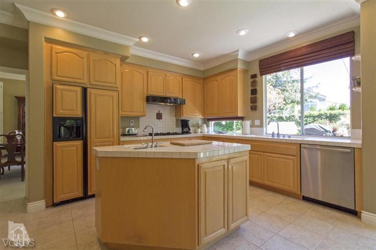 11210 Bentcreek Road Moorpark, CA 93021 - Photo 8 of 22 a kitchen with kitchen island granite countertop white cabinets and refrigerator